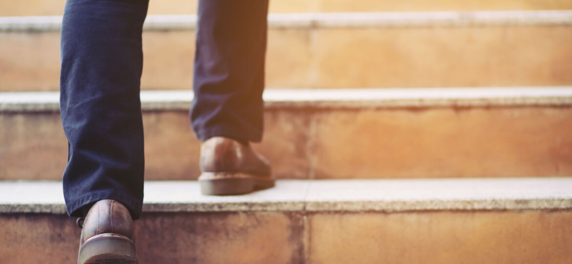 modern businessman working  close-up legs walking up the stairs in modern city. in rush hour to work in office a hurry. During the first morning of work. stairway. soft focus.